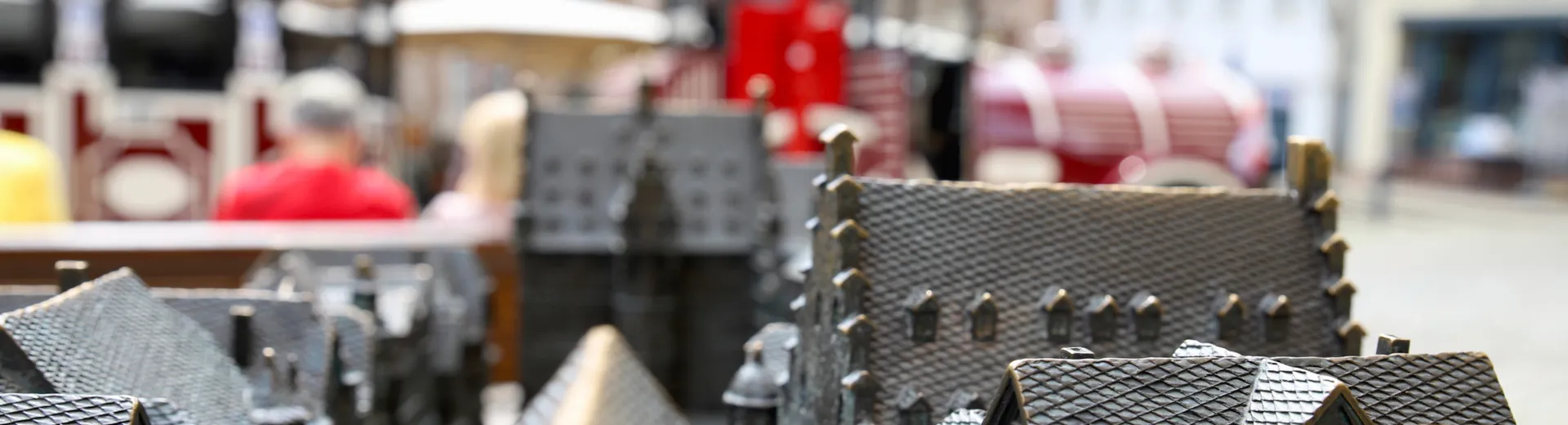 Tastmodell der Marburger Innenstadt auf dem Marktplatz. Im Hintergrund sind verschwommen die Marburger Schlossbahn und ein Buchladen zu sehen. Verteilseite Innenstadtenwicklung