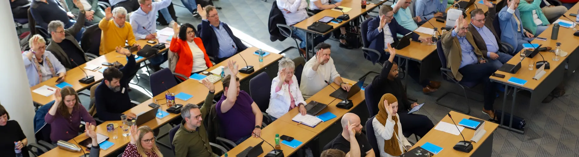 Blick in den Sitzungssaal der Stadtverordnetenversammlung bei der konstituierenden Sitzung im April 2026, die Mehrheit der Abgeordneten hebt die Hand. Verteilseite Stadtpolitik