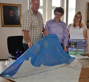 Mit einer Plastikplane Zeichen setzen – hunderte von Menschen aus der Partnerstadt Sfax und Marburg haben das bereits getan. Bürgermeister Dr. Franz Kahle (Mitte) und die Ansprechpartnerin für Städtepartnerschaften der Stadt Marburg, Lisa Bast (r.), macht