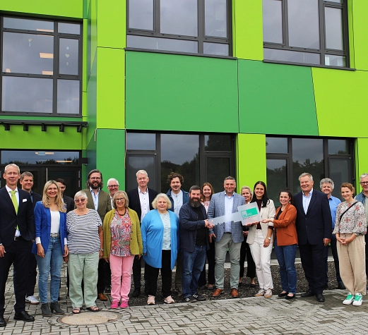 2 Gruppe Modulbau ALS Eine Gruppe von Personen steht vor der Astrid-Lindgren-Schule.