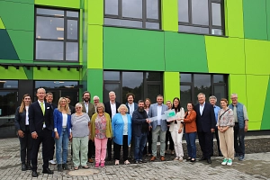 2 Gruppe Modulbau ALS Eine Gruppe von Personen steht vor der Astrid-Lindgren-Schule.
