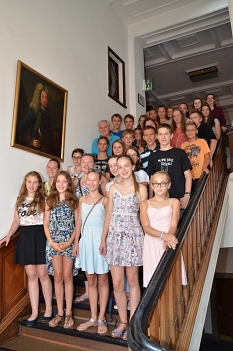 30 junge Gäste passen auf eine Treppe im Rathausgebäude der Universitätsstadt Marburg. Mit dabei auch Stadträtin Dr. Kerstin Weinbach (rechts oben) und Gruppenleiter Damjan (Mitte links). © Universitätsstadt Marburg