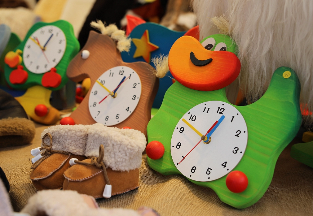 Das Bild zeigt verschiedene Uhren aus Holz mit Kindermotiven.