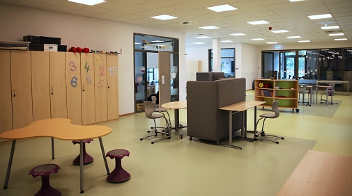 Ein Raum gefüllt mit Stühlen, Tischen und Schränken zur Verbindung der einzelnen Klassenräume.