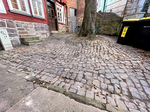 Schloßsteig-Platz vor der Sanierung. Das Pflaster ist uneben, da die Wurzeln der Linde die Steine nach oben drücken.