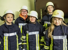 Gruppenbild mit fünf Teilnehmerinnen des Girls'Day in Feuerwehr-Ausrüstung. © Simone Batz, Stadt Marburg