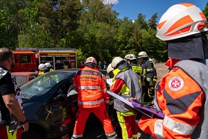 Abschlussprüfung DRK 2026 Mehrere Rettungskräfte stehen um ein Fahrzeug herum. Sie versuchen, jemanden aus dem Fahrzeug zu befreien. Es handelt sich um eine Übung.