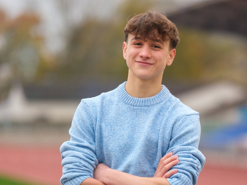 Porträt eines Jugendlichen mit hellblauem Pullover.