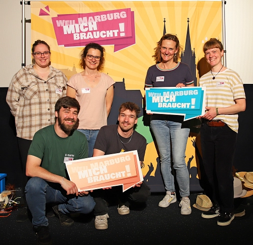 Eine Gruppe von Personen auf der Ausbildungsmesse. Sie halten Schilder hoch, auf denen steht "Weil Marburg mich braucht".&nbsp;&copy;&nbsp;Stefanie Ingwersen, Stadt Marburg