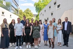 Azubi_Abschlussfeier Auf dem Bild sieht man 14 Personen, gemischt aus Damen und Herren, die alle glücklich und zufrieden in die Kamera schauen.