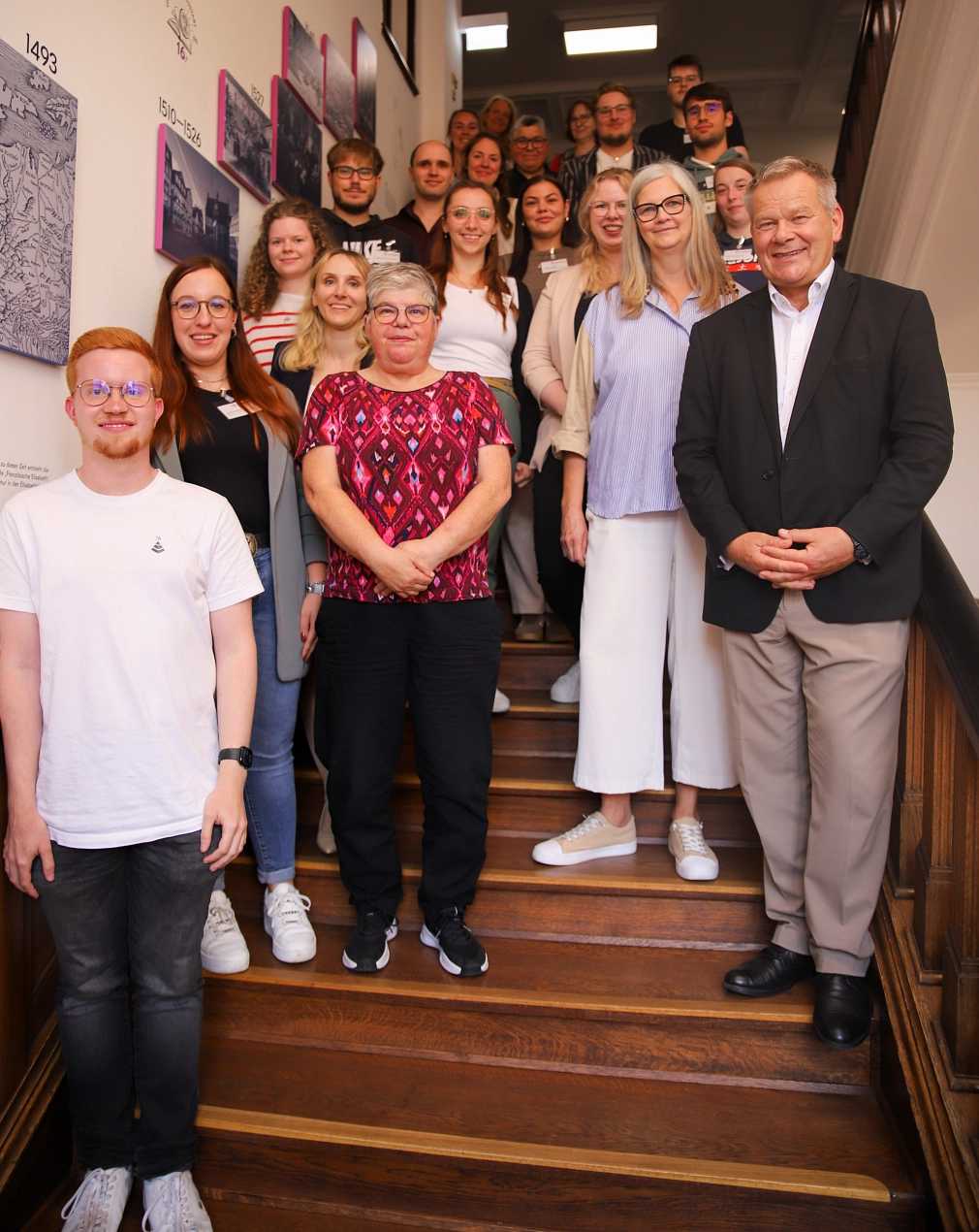 Eine Personen-Gruppe steht auf der Treppe im Rathaus.