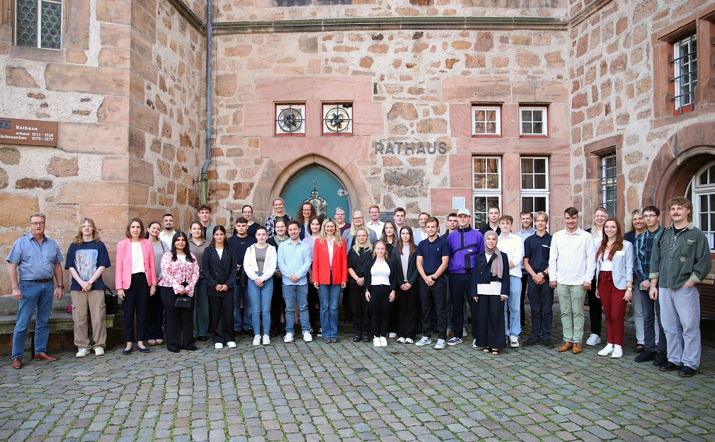 Eine Gruppe von Menschen stehen im Halbkreis vor der Rathaustür.