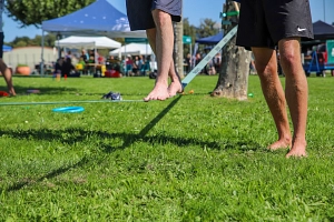 Bewegung für alle (KOMBINE): zum Beispiel auf der Slackline Eine Person balanciert auf einer Slackline, eine Person unterstützt. Zu sehen sind nur die Füße.