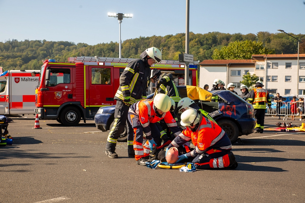 Das Bild zeigt Personen der Feuerwehr und des Rettungsdienstes bei einer Übung am Boden.