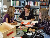 Drei Schülerinnen arbeiten in einer kleinen Arbeitsgruppe anhand verschiedener Gegenstände eine Performance aus. © Universitätsstadt Marburg