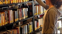 Eine Frau vor einem Bücherregal