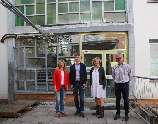 Bürgermeisterin Nadine Bernshausen (v.l.) und Hendrik Schmidt (Fachdienstleiter Hochbau der Stadt Marburg) sowie Ute Kramm und Holger Waldschmidt vom Architekturbüro aplus Architektur Gießen stehen vor der Glasfassade der Sophie-von-Brabant-Schule.&nbsp;&copy;&nbsp;Stefanie Ingwersen, Stadt Marburg