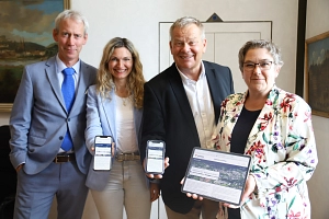 Die vier Dezernent*innen haben auf Handys und Tablet das neue Dashboard geöffnet.