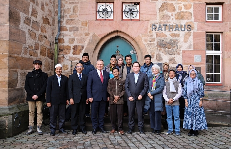 Das Bild zeigt die Delegation aus Indonesien gemeinsam mit Oberbürgermeister Dr. Thomas Spies und den Vertreter*innen der Philipps-Universität vor dem Marburger Rathaus. © Stefanie Ingwersen, Stadt Marburg