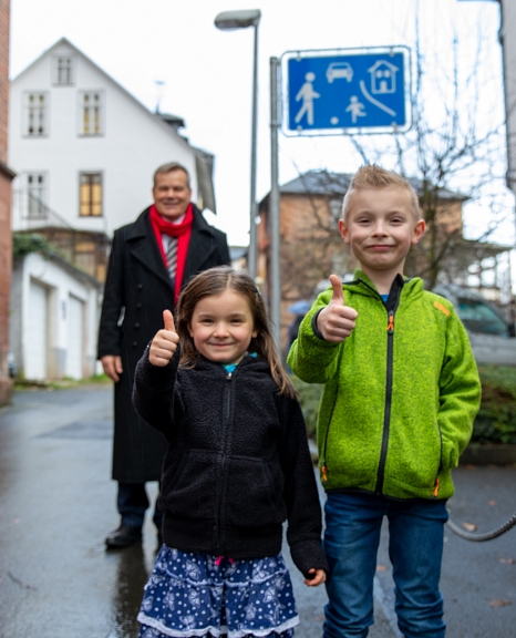 Der achtjährige Franz Ellenberger und seine fünfjährige Schwester Karla freuen sich mit Oberbürgermeister Dr. Thomas Spies darüber, dass das Sauersgässchen nun eine Spielstraße ist und die Stadt damit einem jungen Bürger einen Wunsch erfüllt hat. © Patricia Grähling, Stadt Marburg