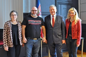 Dienstjubiläum Thorsten Rucker Das Bild zeigt vier Personen (zwei Frauen und zwei Männer), die nebeneinander stehen und in die Kamera lächeln.