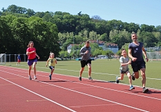 Zwei Kinder und drei Erwachsene rennen auf dem Sportplatz. © Stefanie Ingwersen, Stadt Marburg
