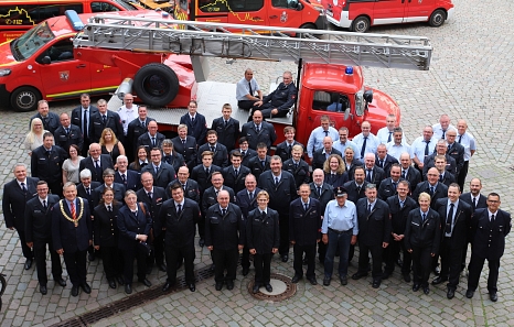 Mehr als 60 Feuerwehrleute aus Marburg wurden auf dem jährlich stattfindenden Ehrungsabend für ihr Engagement ausgezeichnet. Sie stehen auf dem Marktplatz vor dem Rathaus. © Lena-Johanna Schmidt, Stadt Marburg