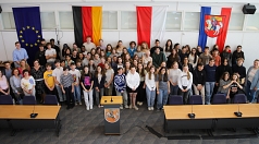 Eine Gruppe von Schüler*innen aus Marburg und Poitiers steht zusammen im Stadtverordnetensitzungssaal.