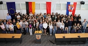 Eine Gruppe von Schüler*innen aus Marburg und Poitiers steht zusammen im Stadtverordnetensitzungssaal.