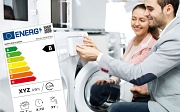 Es sind eine Frau und ein Mann zu sehen, die zusammen eine Waschmaschine bedienen. Dazu ist ein Energielabel eingeblendet.