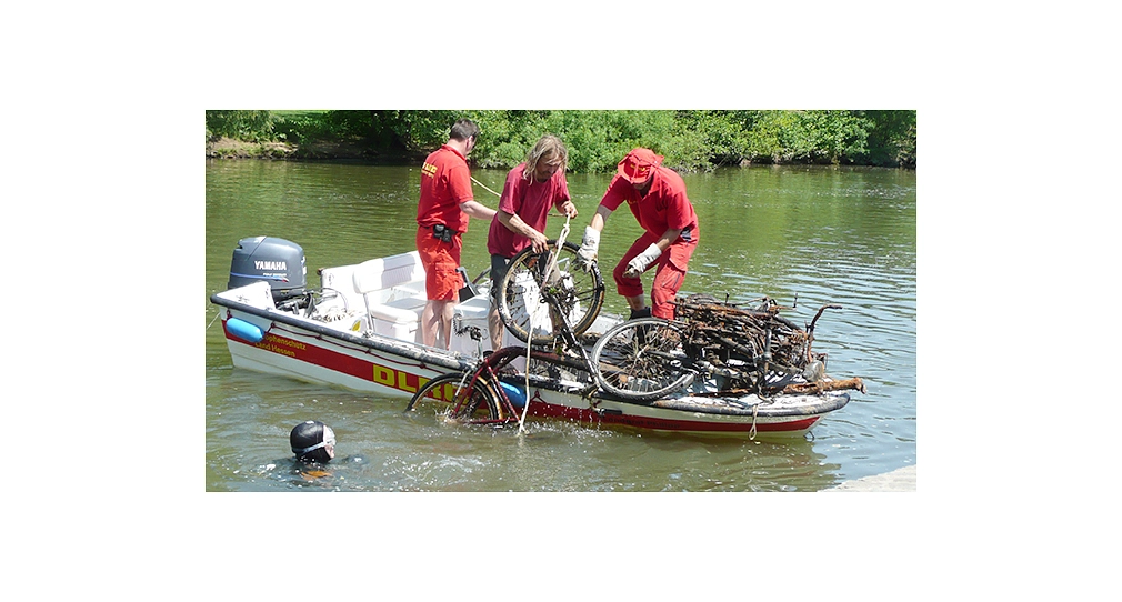 Fahhrad aus der Lahn bergen Das Foto zeigt Freiwillige der DLRG, die ein Fahrrad aus der Lahn in ein Motorboot hieven. © DBM, Sonja Stender