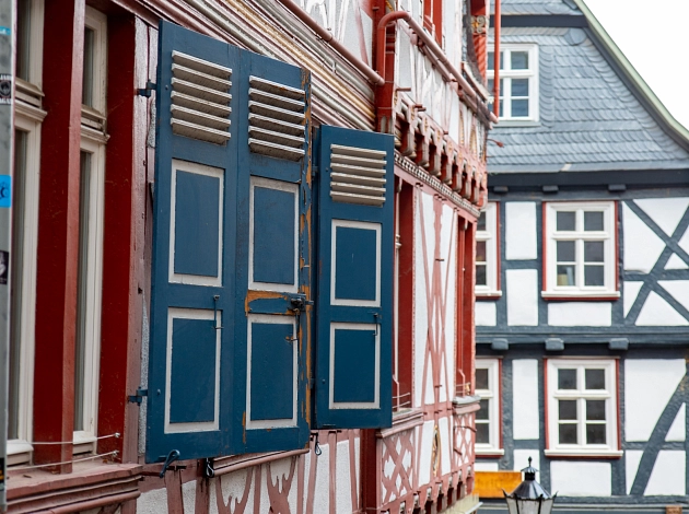Nahaufnahme eines Fachwerkhauses in der Marburger Oberstadt. Farbenfrohe Fenster und Fensterläden.