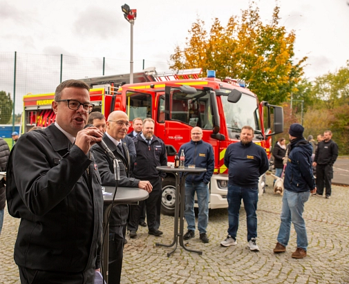 Das Bild zeigt Personen vor einem Feuerwehrauto. Ein Mann spricht in ein Mikrofon.&nbsp;&copy;&nbsp;Patricia Grähling, Stadt Marburg