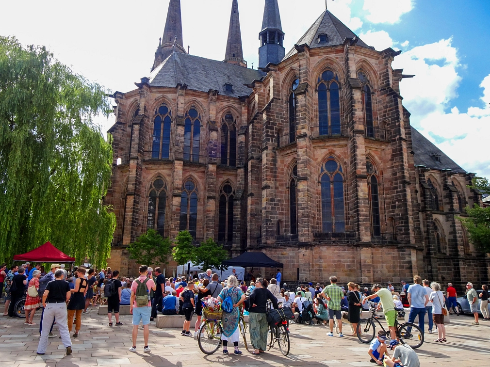 Firmaneiplatz_Foto Monika Bunk, Stadt Marburg.jpg Viele Menschen sind auf dem Firmaneiplatz vor der Elisabethkirche. Sie gucken sich ein Bühnenprogramm an. © Monika Bunk, Stadt Marburg
