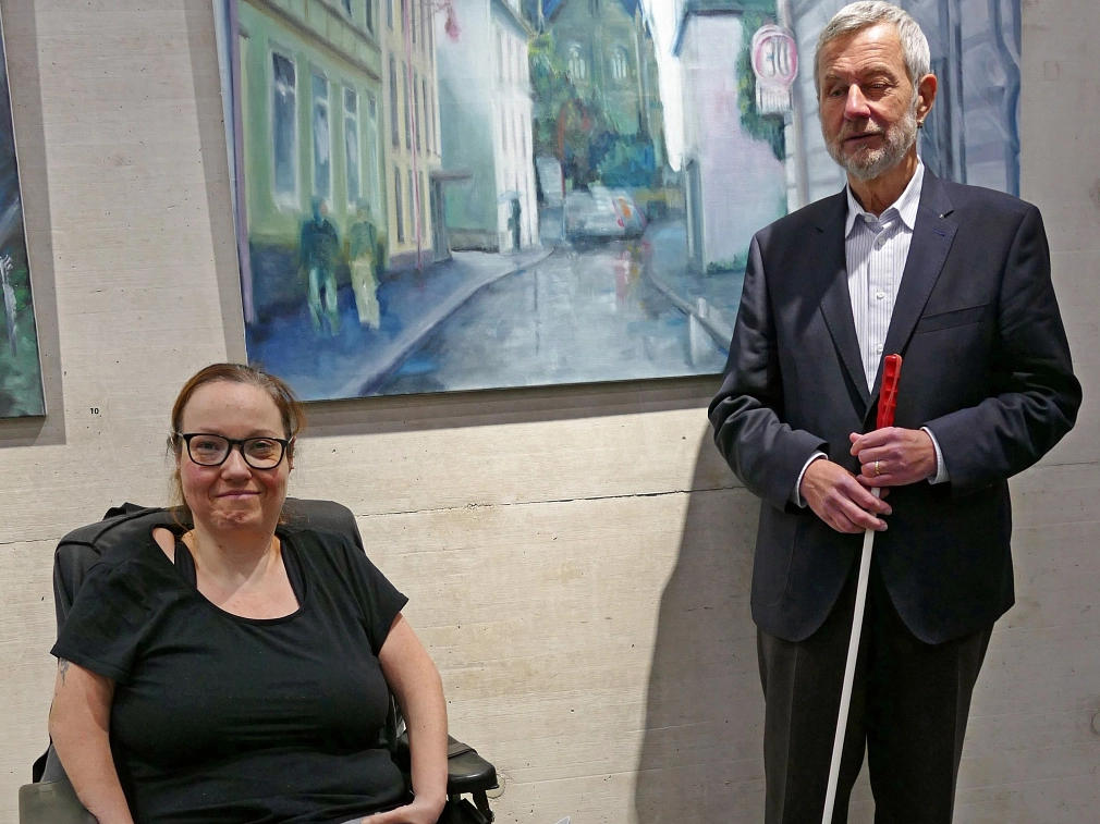 Franz Josef Breiner und Stefanie Ingiulla bilden den Vorstand des Behindertenbeirates. Franz Josef Breiner steht neben Stefanie Ingiulla vor einer Wand im Erwin-Piscator-Haus. © Ulrich Severin