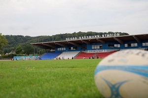 Georg-Gaßmann-Stadion_Foto Dennis Siepmann, Stadt Marburg Es ist ein Ball auf einem Rasen zu sehen. Im Hintergrund erkennt man das Georg- Gaßmann-Stadion.