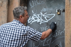 Ralf Schmidt, Leiter des DBM-Servicehofs, zeigt, wie Graffiti mit verschiedenen Pasten und Flüssigkeiten entfernt werden können. © Stadt Marburg, Patricia Grähling