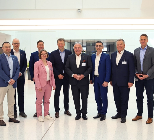 Gruppe_Besuch Pharma-Standort_Foto Stefanie Ingwersen, Stadt Marburg.jpg Eine Gruppe von Personen steht lächelnd nebeneinander und der Kamera zugewandt in einem Gebäude des Pharma-Standorts.