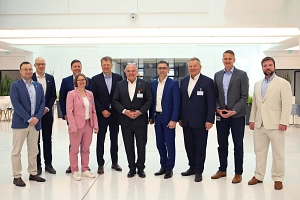 Eine Gruppe von Personen steht lächelnd nebeneinander und der Kamera zugewandt in einem Gebäude des Pharma-Standorts.