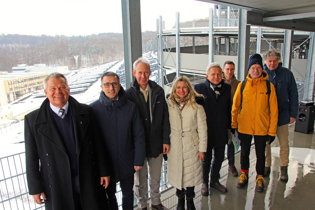 Eine Gruppe von Personen stehen in einem Parkhaus. Alle lächeln in die Kamera.