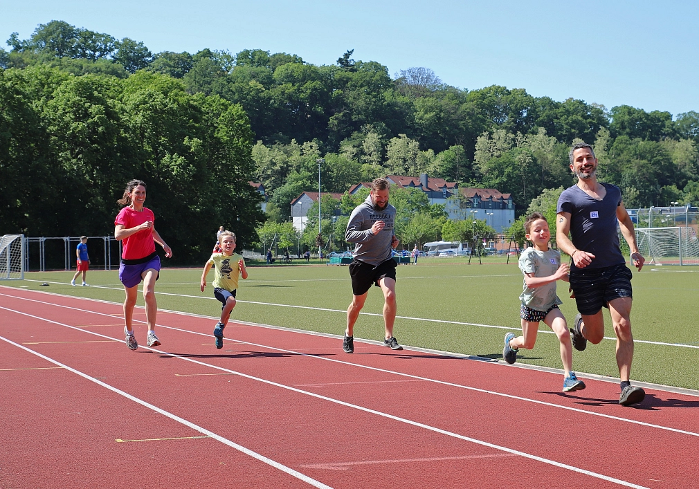 Eine Frau, zwei Männer und zwei Kinder laufen auf einer Laufbahn und lachen fröhlich.&nbsp;&copy;&nbsp;Stefanie Ingwersen, Stadt Marburg