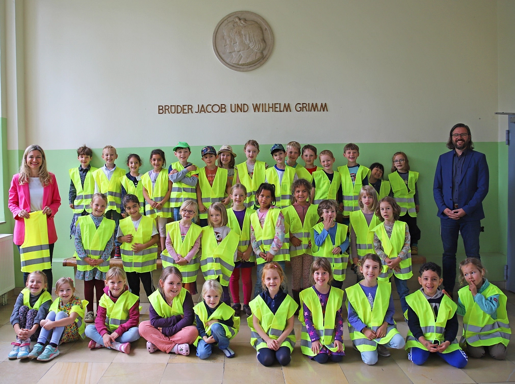 Das Bild zeigt eine Gruppe von Kindern, die Warnwesten an haben.