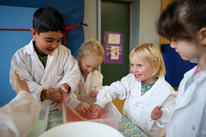 Kita-Kinder experimentieren mit Chemikum und GSK 2025 Vier Kinder matschen in einer Plastikkiste.
