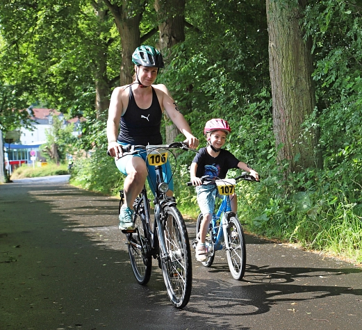 KuFamTri2025 Es sind zwei Personen zu sehen, die Fahrrad fahren.