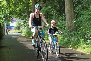 KuFamTri2025 Es sind zwei Personen zu sehen, die Fahrrad fahren.