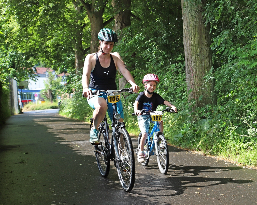 Es sind zwei Personen zu sehen, die Fahrrad fahren.