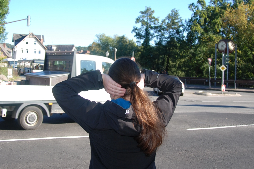 Lärm an der Straße - hier am Rudolphsplatz Rudolphsplatz in Marburg: Rückansicht einer Frau, die sich die Ohren zuhält. Ein LKW fährt an ihr vorbei. © Universitätsstadt Marburg