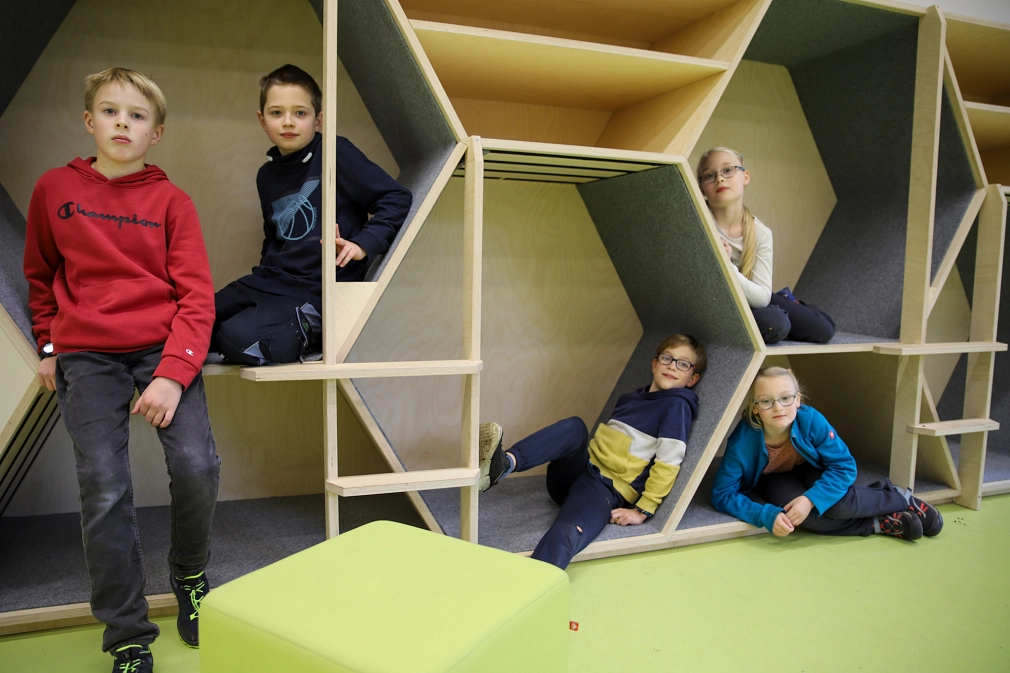 Mehrere Kinder sitzen in über- und nebeneinander angeordnete Sechsecke aus Holz, deren Optik an Bienenwaben erinnert.&nbsp;&copy;&nbsp;Freya Altmüller, Stadt Marburg