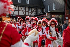 Mädchen und Frauen in rot-weißen Kostümen werfen Popcorn in die Menge. © Patricia Grähling, Stadt Marburg