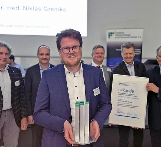 MarBiNa-Preis 2026 Der Preisträger steht vor einer Gruppe von fünf Personen.